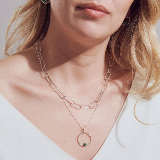Silver 950 layered necklace with a textured chain and a circular pendant featuring a Colombian emerald.