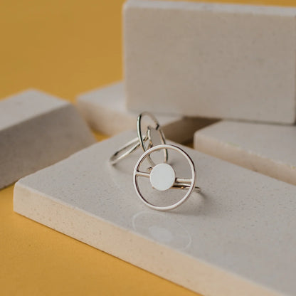 Handmade Anillo Eclipse ring in recycled 950 silver with a modern circular design and white center.