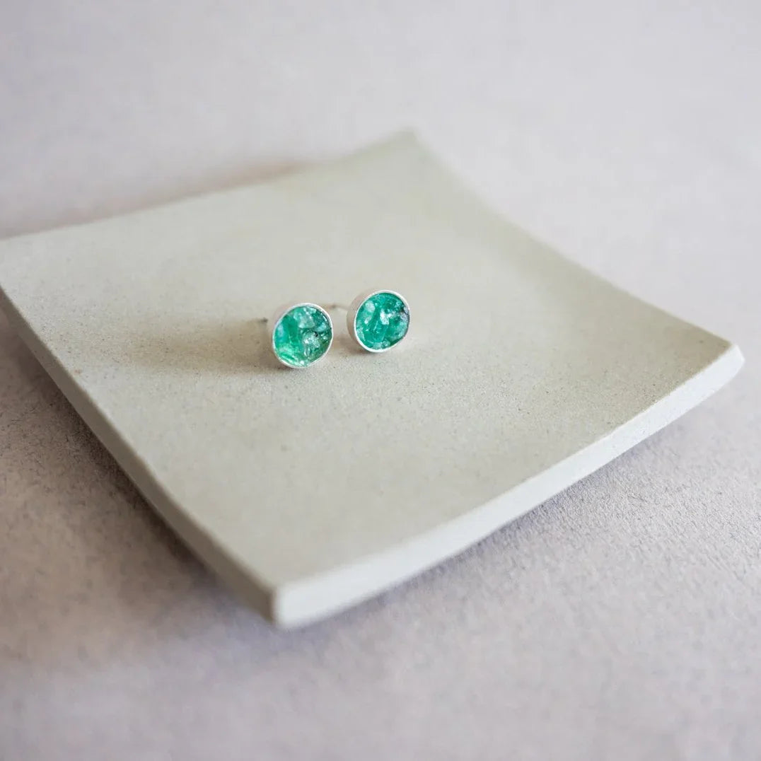 Round stud earrings with vibrant green Colombian emeralds in recycled 950 silver settings.