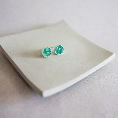 Round stud earrings with vibrant green Colombian emeralds in recycled 950 silver settings.