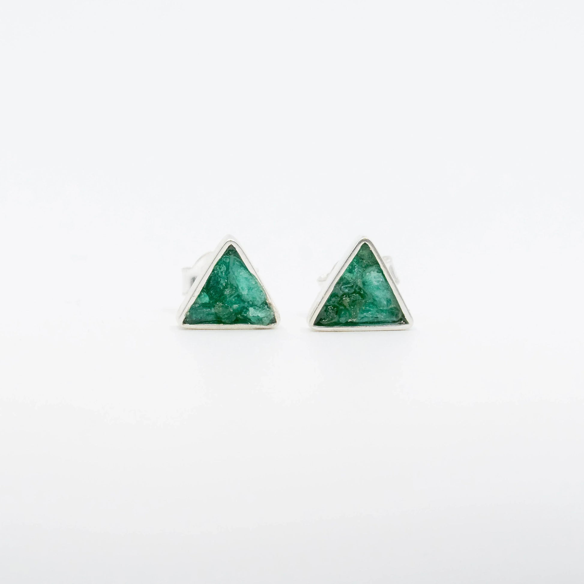 Handmade triangular silver stud earrings with raw Colombian emeralds.