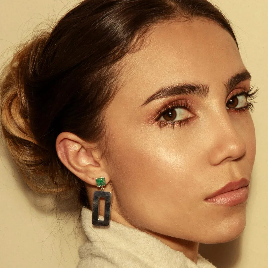 Silver dangle earrings with a square emerald stud and a rectangular moving pendant.