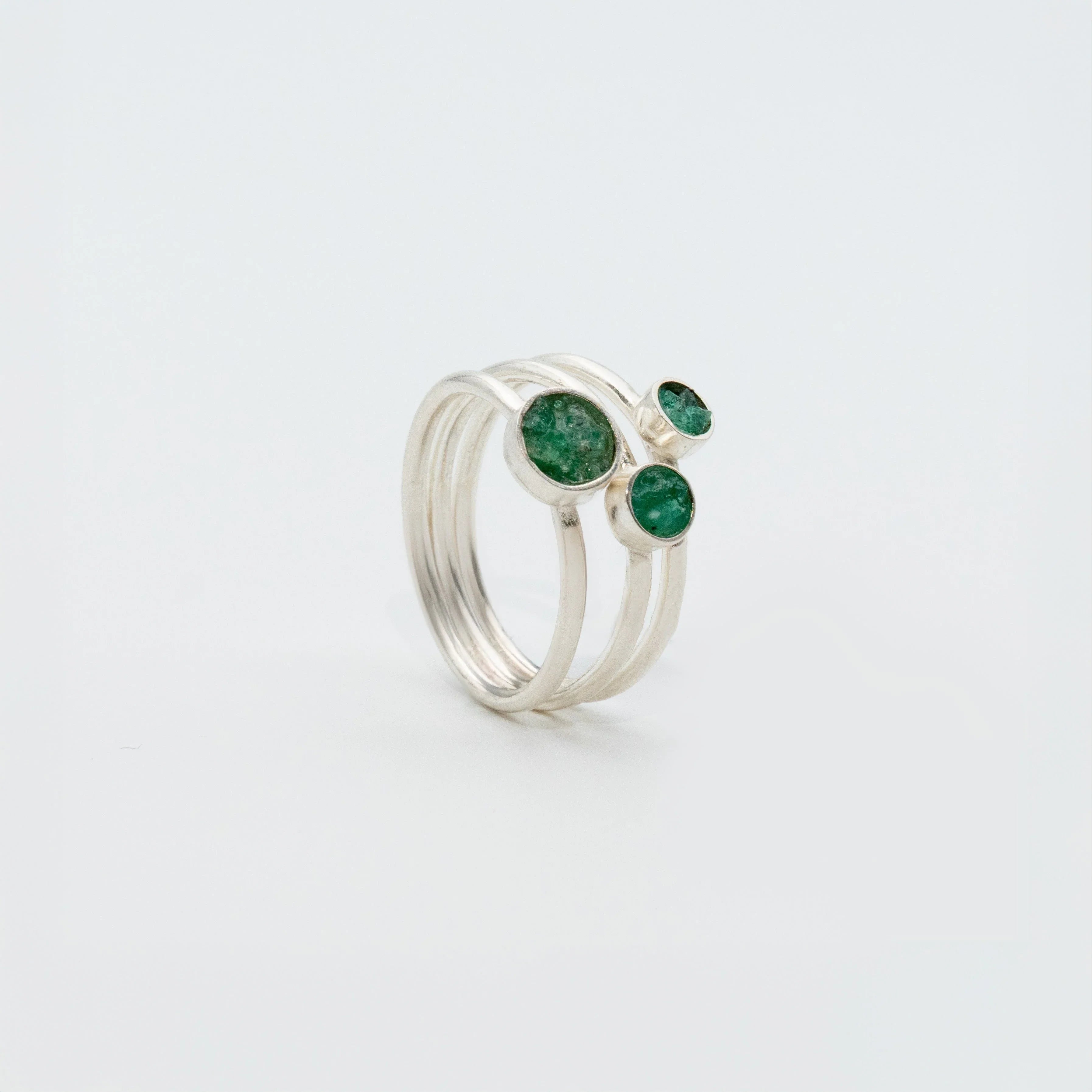 Silver 950 ring with three round, raw Colombian emeralds on a triple band.