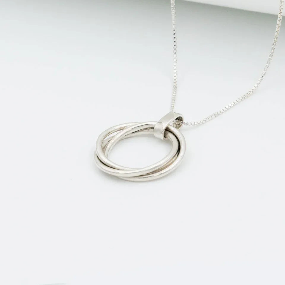 Dije tres círculos plata 950 entrelazados. Joyería artesanal geométrica. Diseño simbólico hecho a mano.