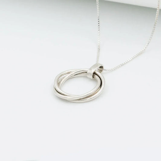Dije tres círculos plata 950 entrelazados. Joyería artesanal geométrica. Diseño simbólico hecho a mano.