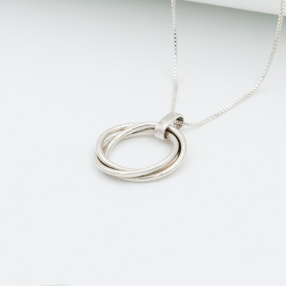 Dije tres círculos plata 950 entrelazados. Joyería artesanal geométrica. Diseño simbólico hecho a mano.