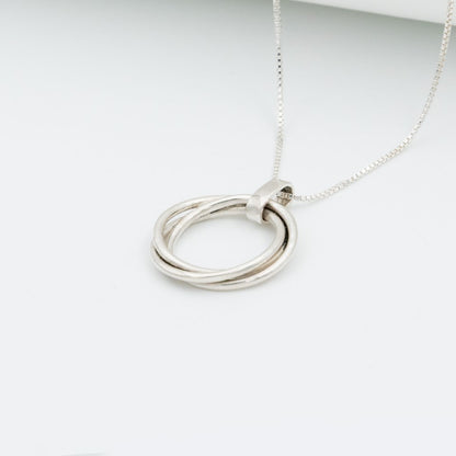Dije tres círculos plata 950 entrelazados. Joyería artesanal geométrica. Diseño simbólico hecho a mano.