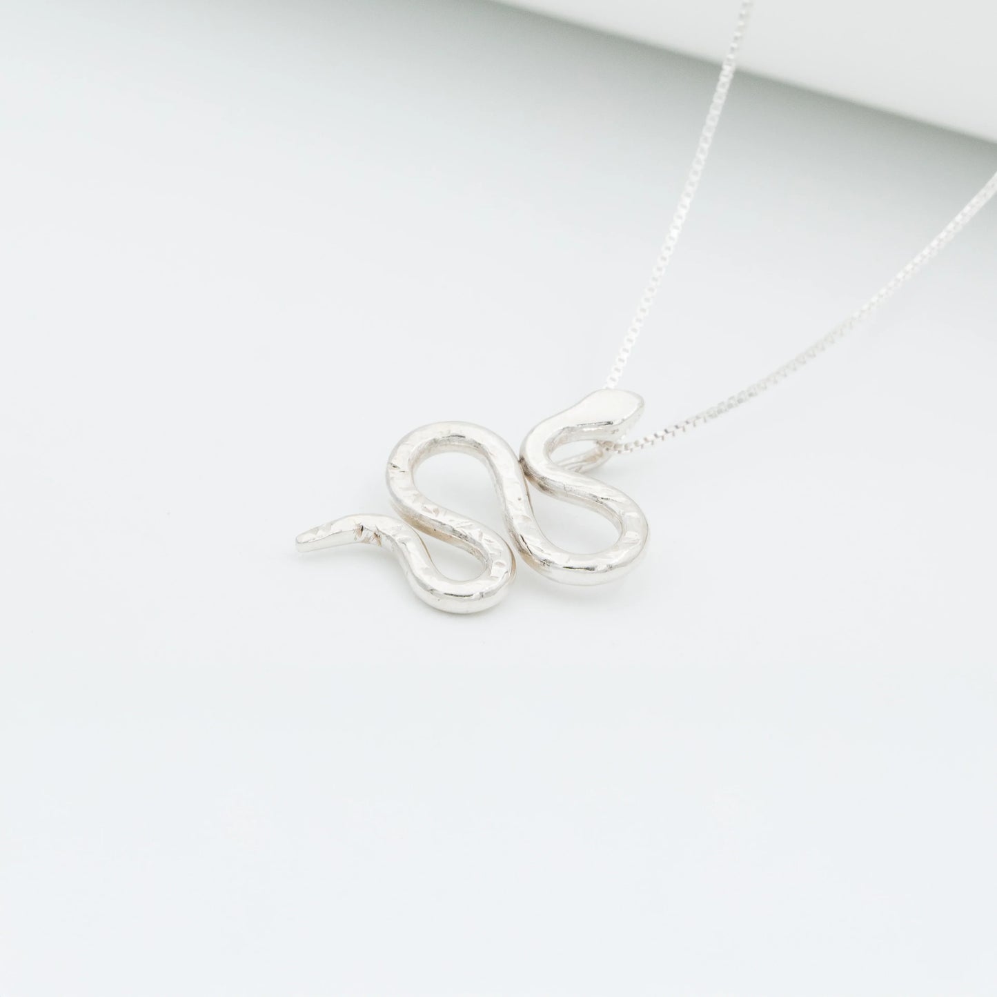 Silver 950 Mamba snake pendant necklace with a textured, handcrafted design on a white background.