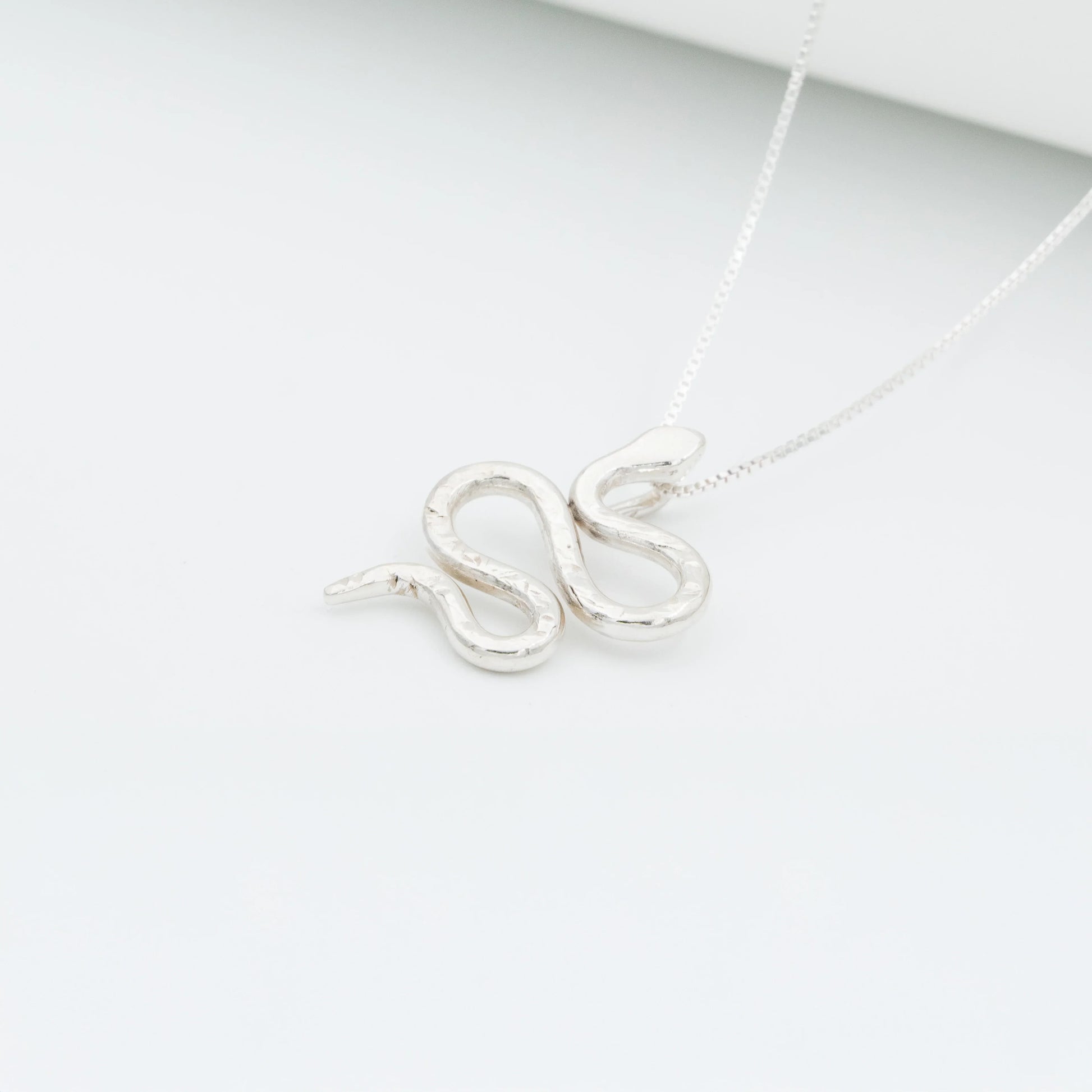 Silver 950 Mamba snake pendant necklace with a textured, handcrafted design on a white background.