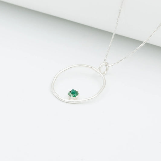 Handmade recycled silver 950 necklace with an organic open circle pendant and a raw Colombian emerald.
