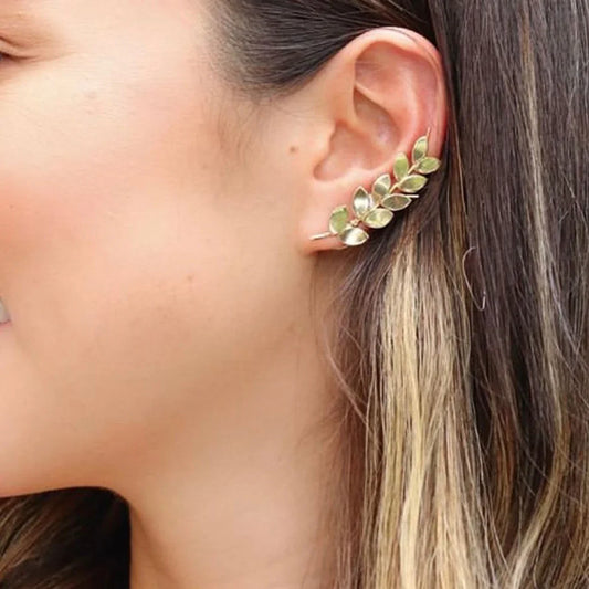 Gold-plated 950 silver ear cuff with a delicate leaf design, worn on a woman's ear.